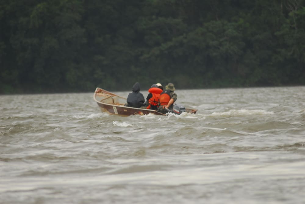 subida do rio Iguaçu em direção a checagem das armadilhas. Um barco com pesquisadores passando por uma corredeira