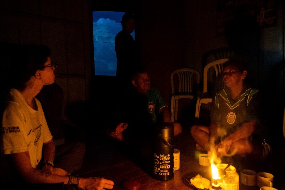 uma tipica abordagem com a comunidade na amazonia central.  A luz de velas, pesquisadora conversa com os ribeirinhos sobre os animais da amazonia central
